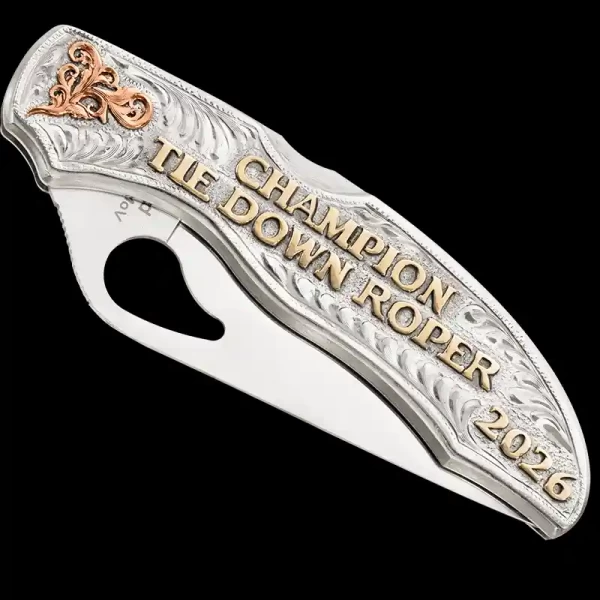 "Experience the perfect blend of craftsmanship and customization.

Our Dusty Trail Custom Knife is crafted using a SpyderCo Byrd knife and a German Silver plate. This masterpiece features hand-engraved Copper western-inspired scrolls and striking J